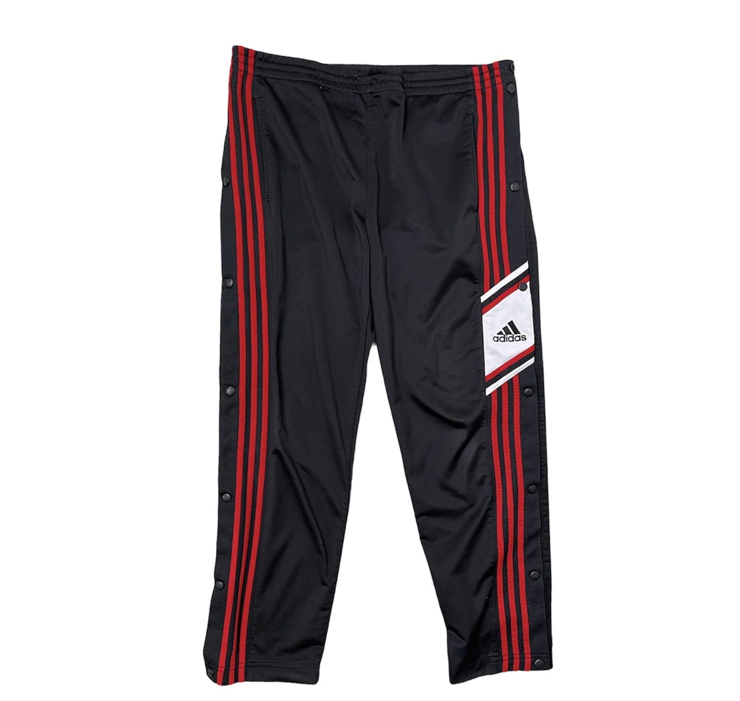 Pantalone tuta Adidas vintage da uomo nero con righe verticali rosse e bottoni neri ai lati e con logo Adidas nero su sfondo bianco sul lato sinistro, sopra le strisce