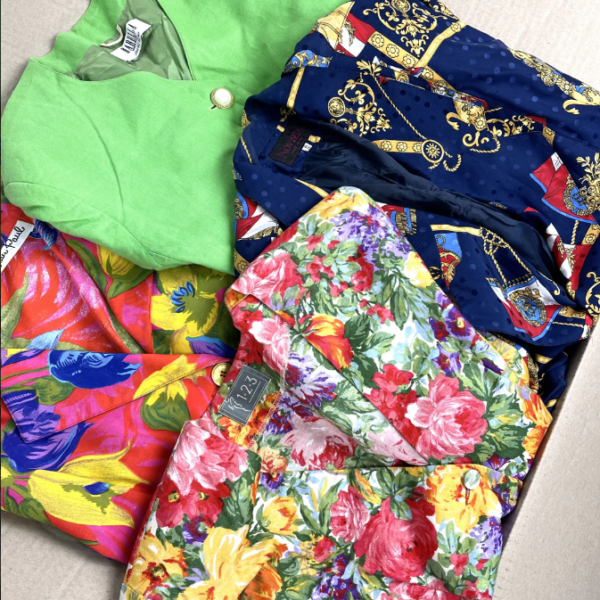 Quattro giacche usate anni 90 di vari colori e pattern sia da uomo che da donna all'interno di una scatola