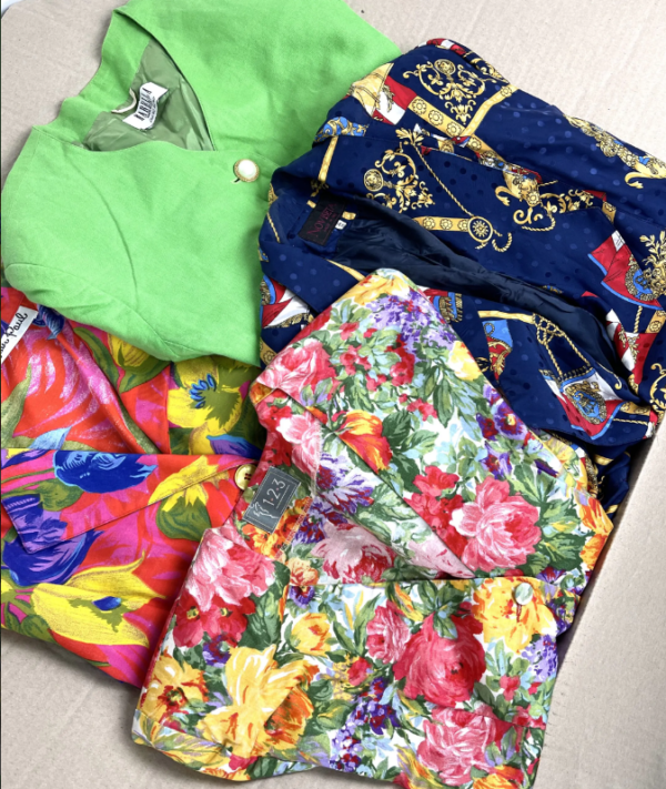 Quattro giacche usate anni 90 di vari colori e pattern sia da uomo che da donna all'interno di una scatola